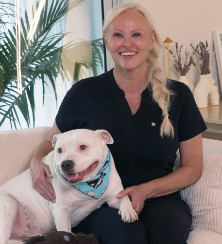 Patricia G and her dog pose inside her home
