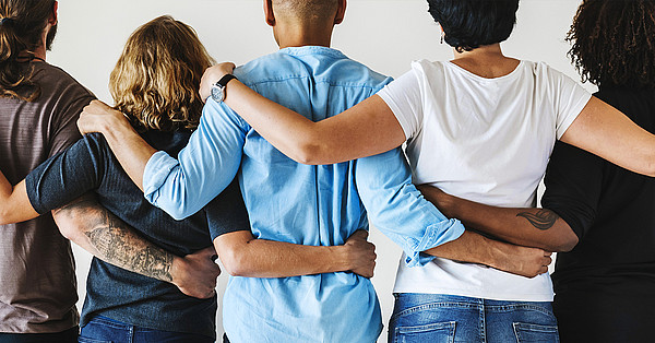 Vernetzung Das Bild zeigt 5 stehende Arm in Arm Personen von hinten